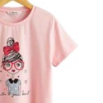 Polera rosada de niña con ilustración de personaje con moño y lentes. - Imagen 3